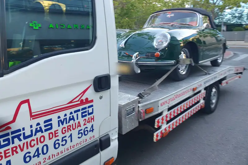 Grúa de plataforma con un Porsche 356 clásico cargado