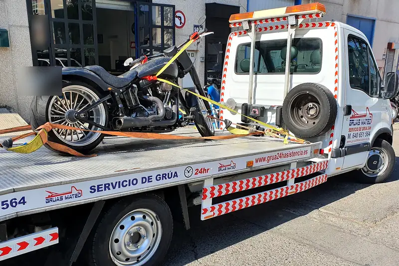 Grúa para motos con una moto custom amarrada con cinchas en la plataforma